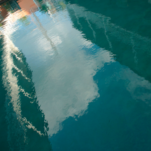 A photo of water showing reflections of buildings.