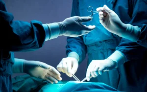 surgeons working on a patient passing instruments to each other in an operating room