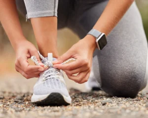 a pair of hands ties a running shoe