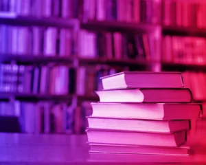 a stack of books on a desk in a library