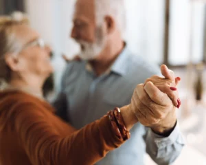 an out of focus image of an older couple dancing together holding hands