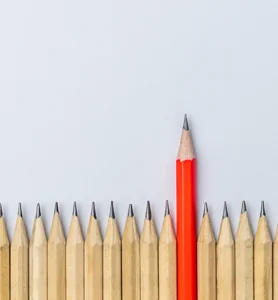 several sharp pencils with one red one standing taller