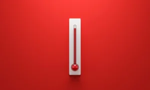 an old style thermometer on a red background