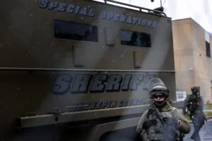 A soldier standing in front of a special operations sheriffs vehicle