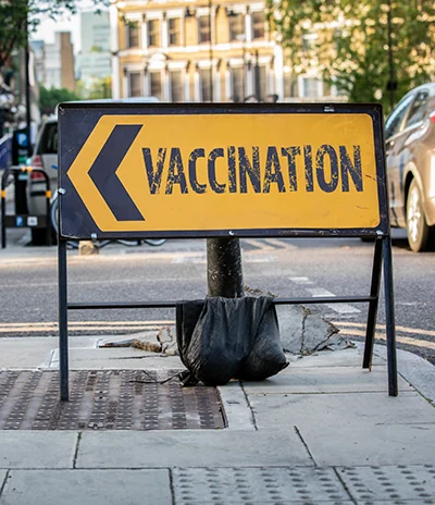 A sign with an arrow that says Vaccination