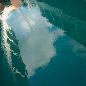 A photo of water showing reflections of buildings.