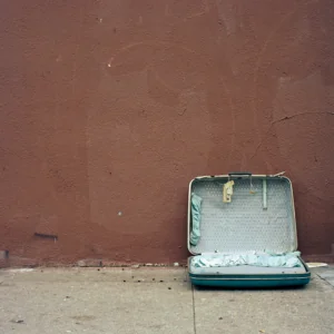 Empty suitcase lies open on the sidewalk