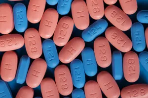 Blue and pink HIV/AIDS therapy pills on blue background