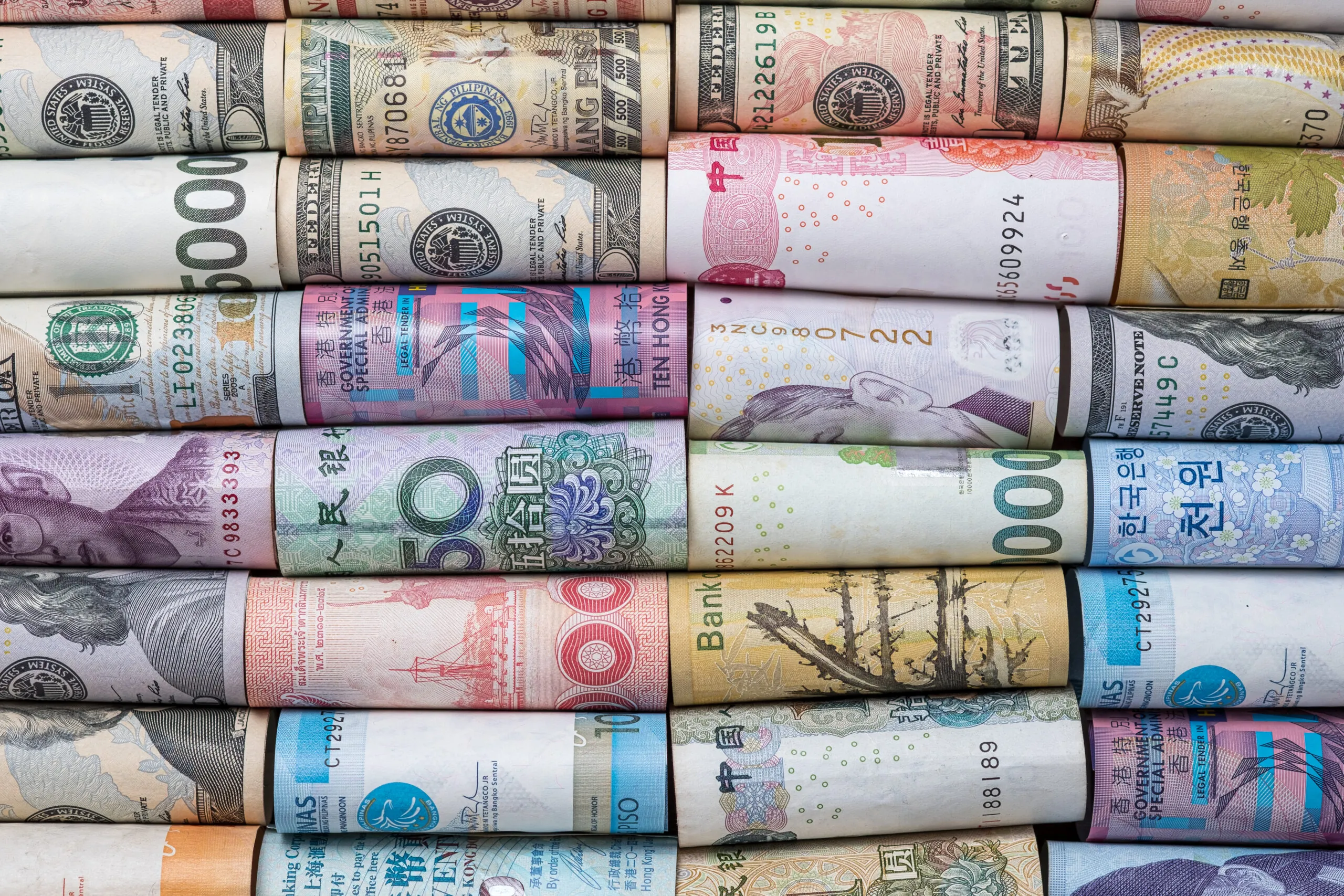 Closeup rolled of variety banknote and multi currency around the world. Exchange rate and Forex investment concept.